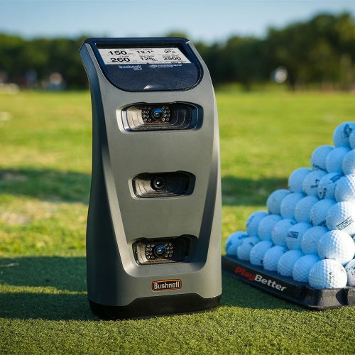 bushnell launch pro golf simulator & launch monitor sitting on a golf driving range in front of some golf balls